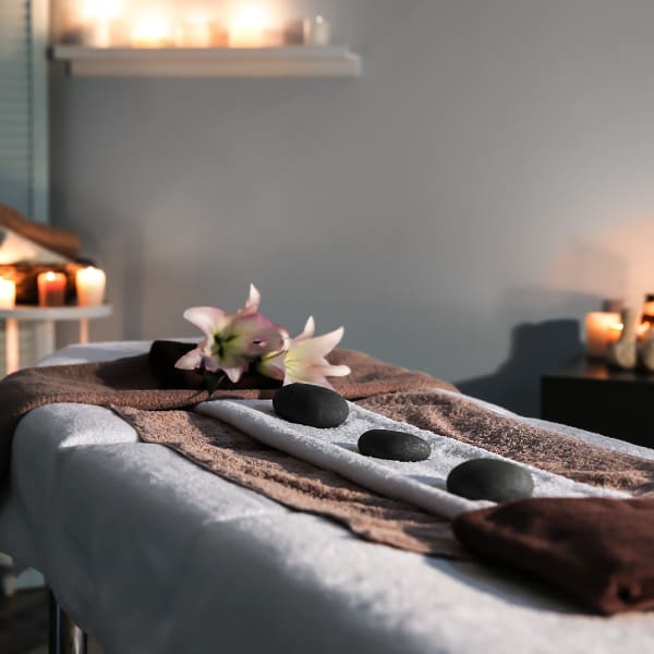Citrus Town Center - Services Massage table prepared with hot stones, towels, and flowers.
